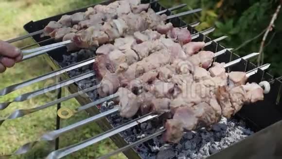 扦子上的生肉近景烤架上的肉片户外烧烤准备食物过程有人把腌肉视频的预览图