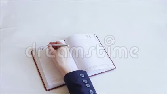 穿西装的人在笔记本上写字视频的预览图