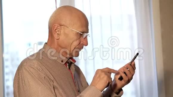 戴眼镜和红衬衫的聪明老头打电话视频的预览图