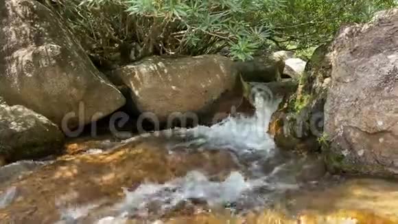 一条山溪流过大石头从水流中流出泡沫视频的预览图