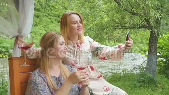 美丽优雅的女人喝红酒在智能手机上拍照享受住在美丽的假日视频的预览图