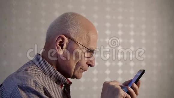 戴眼镜的老人发现了智能手机视频的预览图