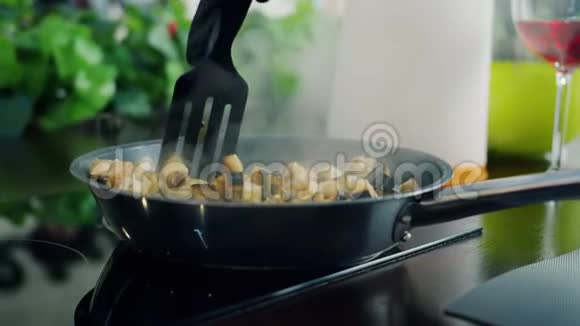 厨师用手在煎锅里搅拌蔬菜在餐馆里做美味的饭菜视频的预览图