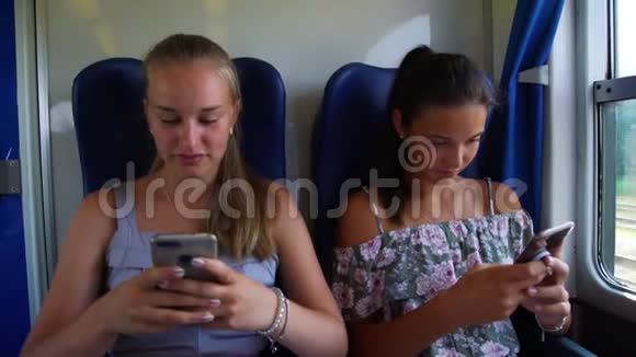可爱的女孩在电话中给火车上的朋友展示照片视频的预览图