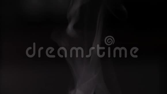 蒸汽的涓涓细流慢慢地从杯中升起白色的蒸汽升起轻盈在黑色的背景上优雅的曲折视频的预览图
