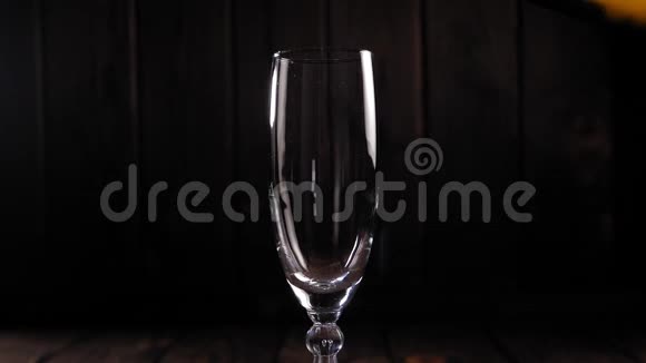 特写的香槟在黑色背景上倒入一个玻璃杯中动作缓慢视频的预览图