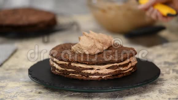 在家做巧克力层的拿破仑蛋糕把奶油蛋糕放在烘焙的糕点上视频的预览图