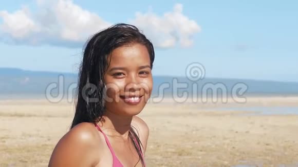 海洋海滩上迷人的亚洲女孩看着镜头微笑的肖像视频的预览图