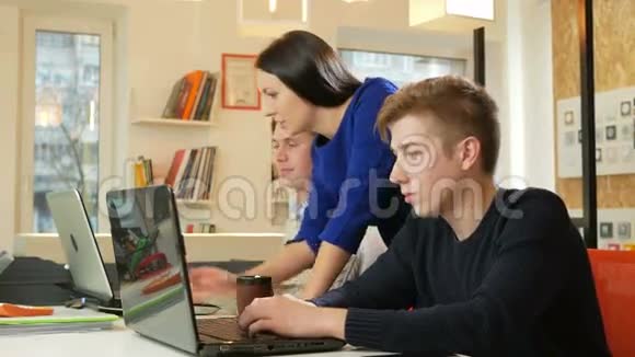 漂亮的女孩在办公室的笔记本电脑上咨询男人关于这个项目的情况它在屏幕上显示了你的手指视频的预览图