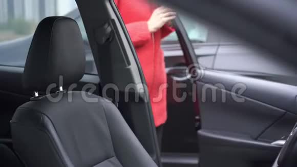 穿红色外套的金发美女上车视频的预览图