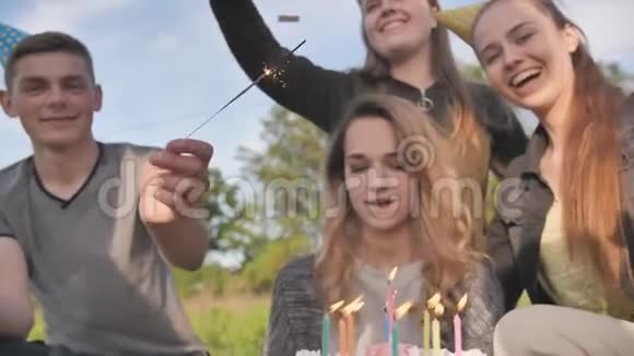 快乐的朋友庆祝他们女朋友生日生日女孩吹灭蜡烛视频的预览图
