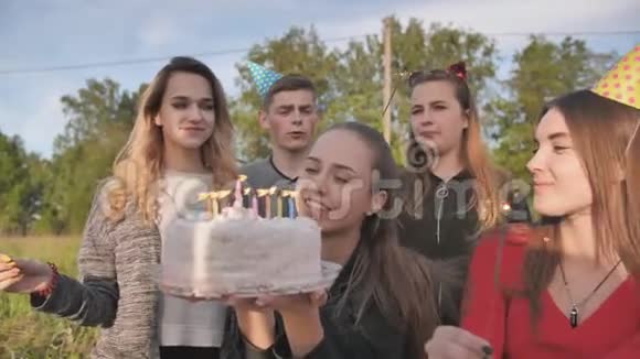 快乐的朋友庆祝他们女朋友生日生日女孩吹灭蜡烛视频的预览图