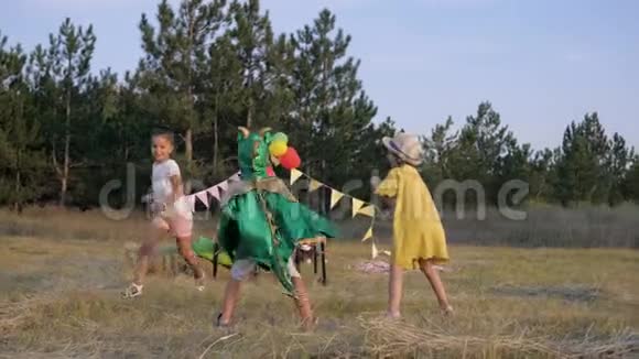 周末在森林里的游戏活跃的孩子们在用假发装饰的空地上跑来跑去在龙中互相捕捉视频的预览图