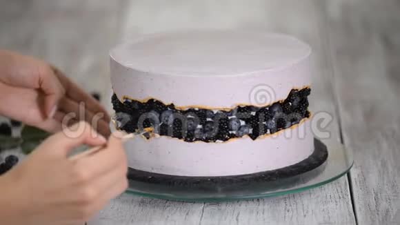 糖果师用金色糖浆装饰浆果蛋糕手工制作视频的预览图