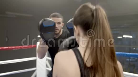 女青年在健身房与教练拳击视频的预览图