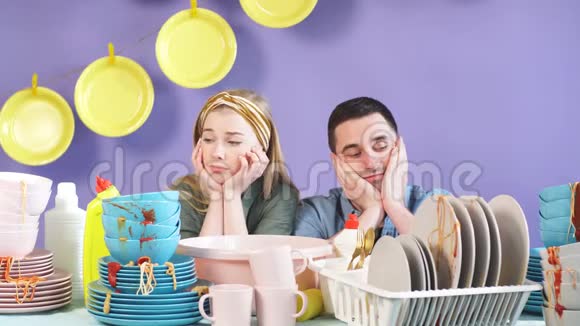 沮丧的沮丧的男人和女人不想在聚会后洗碗视频的预览图