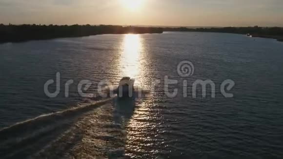 日落时分白船在河上风景优美鸟瞰视频的预览图