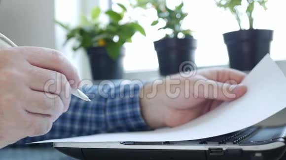 慢动作商人在家工作用笔记本电脑并签署文件冠状病毒危机的工作理念视频的预览图