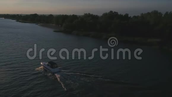 日落时分小白船沿着河涌鸟瞰视频的预览图