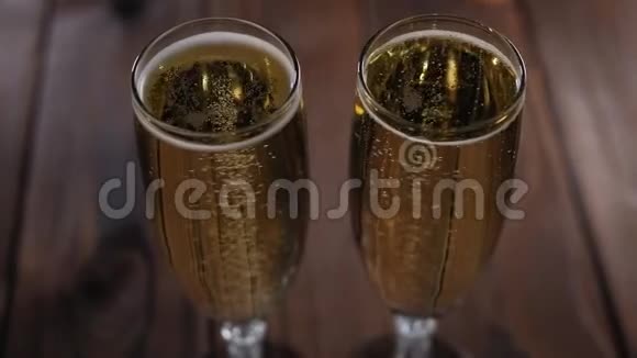 两杯香槟的特写木制背景上有气泡视频的预览图