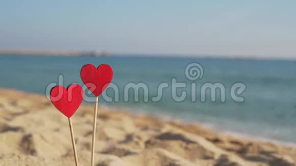 两颗赤红的心在沙滩上映衬着海涛的背景与复制空间视频的预览图