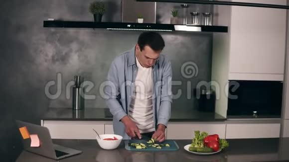 白种人年轻人穿着休闲服装做素食早餐在家厨房切菜做沙拉视频的预览图
