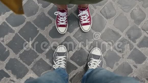 红色和蓝色的运动鞋在铺路石上跳舞从上面拍摄的自拍视频男女双腿穿彩色运动鞋视频的预览图