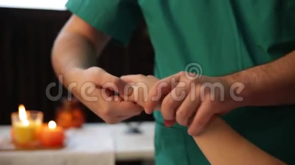 手腕按摩一位男性按摩治疗师把压力压在女人手的敏感点上视频的预览图