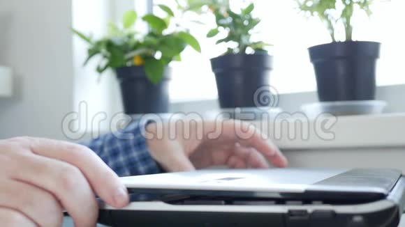 慢动作商人从家庭使用笔记本电脑和互联网连接从远程办公文件工作视频的预览图