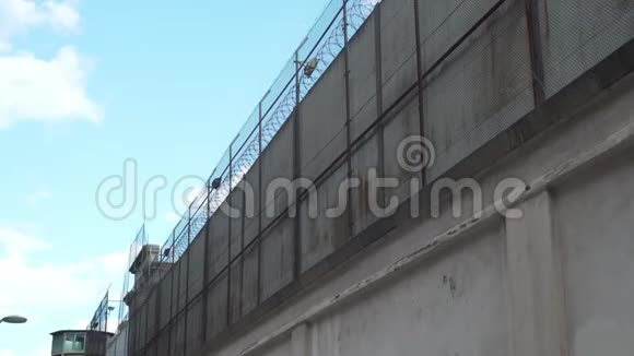 很高的监狱栅栏用铁丝网挡住晴朗的天空视频的预览图