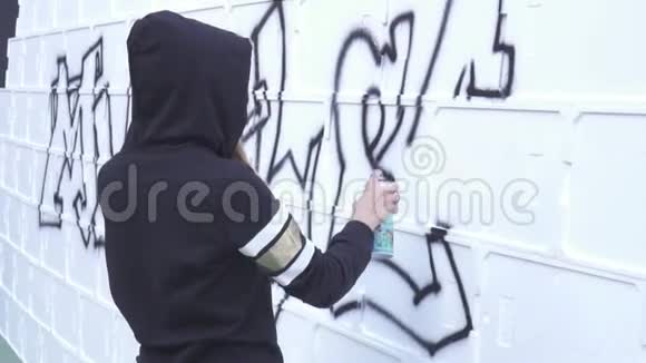 一个女孩用喷雾器在墙上涂鸦视频的预览图