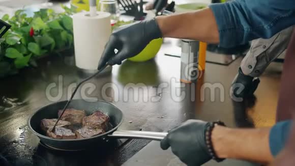 在厨房的锅上用煎锅烹制荤菜视频的预览图