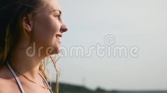 一个苗条的年轻女子在炎热的夏天享受大海慢动作视频的预览图