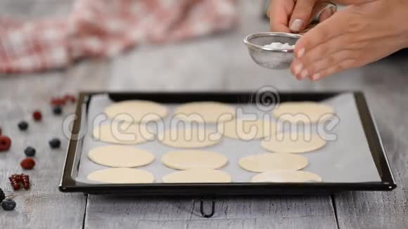 面包师用搅拌器将糖粉撒在膨松糕点上在厨房做法国米尔菲耶视频的预览图