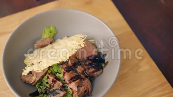 厨房木桌上的一碗熟食肉类和蔬菜视频的预览图