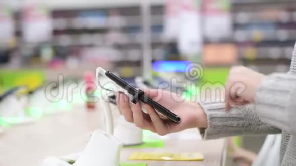 女人在电子商店测试智能手机用手机特写视频的预览图