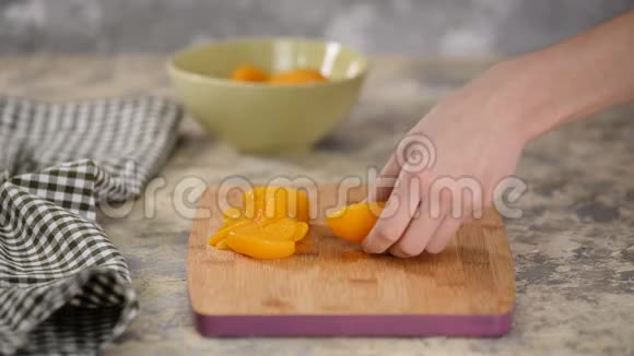 在木切割板上切桃罐头视频的预览图