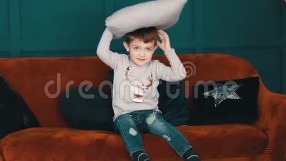 可爱的小男孩在客厅里玩枕头视频的预览图
