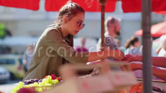 女人向市场上的水果销售人员付钱视频的预览图