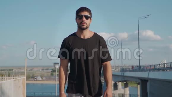 年轻英俊的运动员西班牙或阿拉伯人的外表带着太阳镜的胡须有一个陡峭的散步慢动作视频的预览图