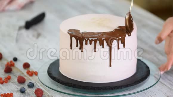 面包师倒液体巧克力甜点面包师装饰大美丽的奶油蛋糕视频的预览图