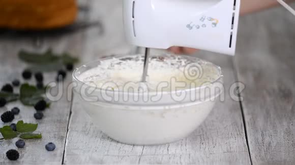 糕点厨师添加浆果果泥到奶油用混合浆果奶油打视频的预览图