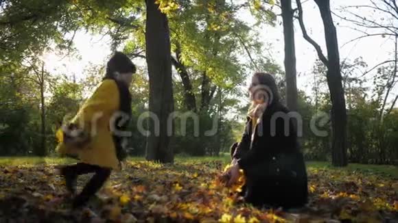 孩子与父母的关系爱心妈妈抱着美丽的女儿在美丽的秋园散步视频的预览图