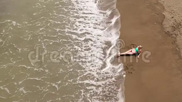 女孩在海滩上休息俯视风景火山沙滩视频的预览图