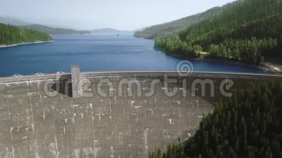 山上大水坝蓝色河流和茂密森林的鸟瞰图视频的预览图