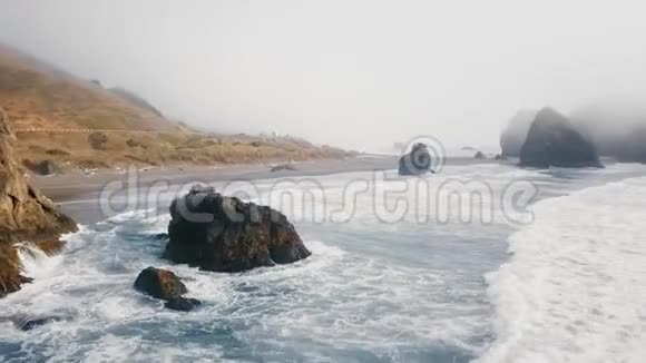 鸟瞰山岸和海浪在岩石上破碎视频的预览图