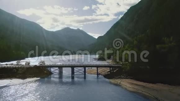 一架无人机照相机拍摄了一座桥桥横跨密林山脉之间的河流视频的预览图
