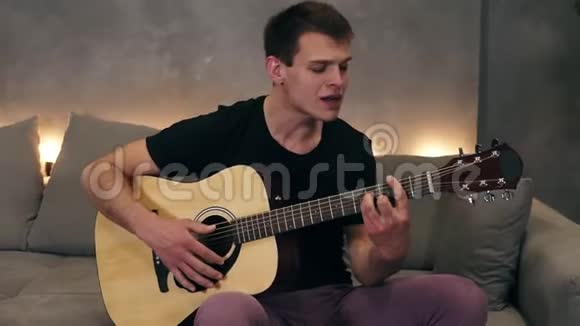 一个快乐的白种人唱着一首歌的特写肖像一边弹着吉他一边享受音乐视频的预览图