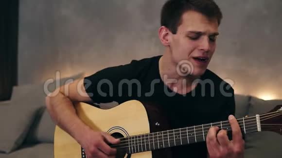 一个欢快的人唱一首抒情的有感情的歌的肖像一边弹着吉他一边享受音乐视频的预览图