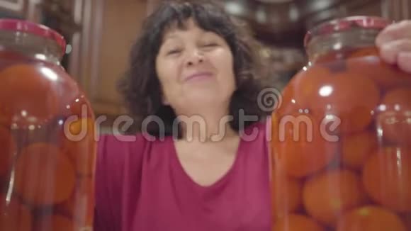 成熟的白人女人把两个瓶子分开在他们之间微笑积极的女性退休者羡慕她的罐头视频的预览图